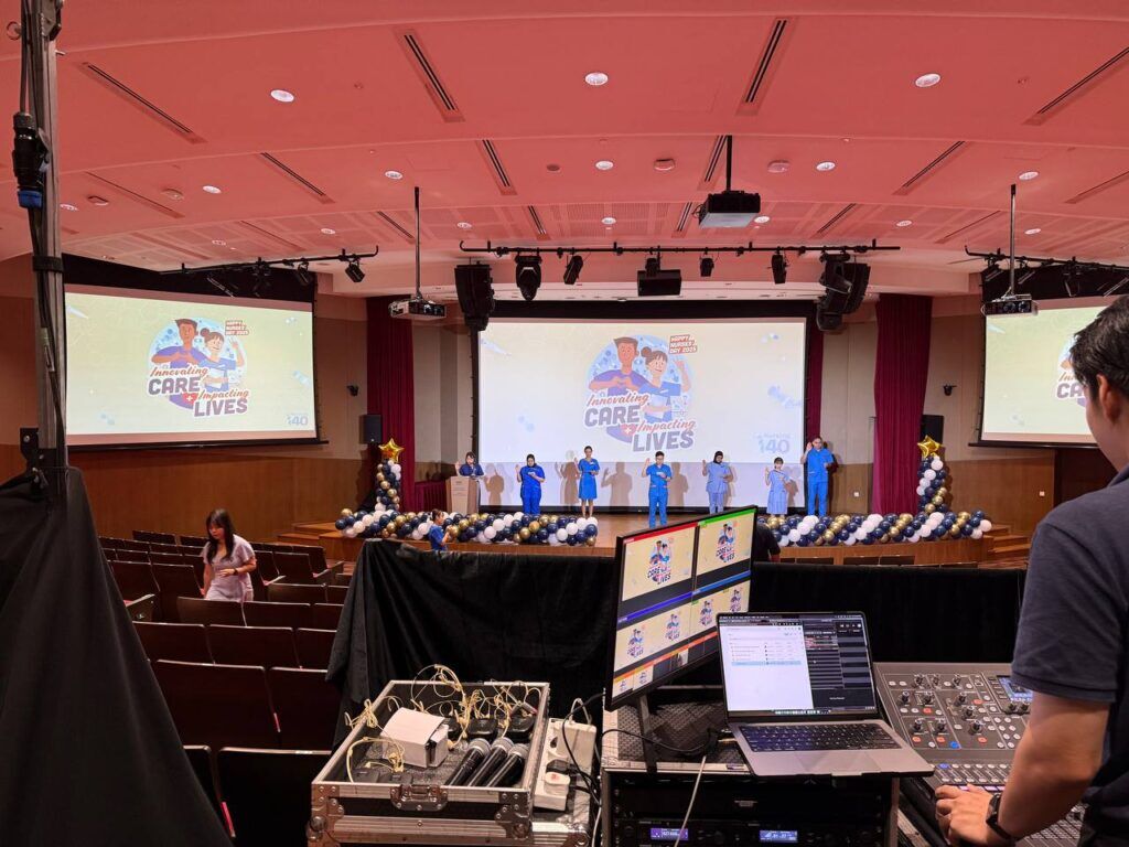 Audio and video production desk facing the main stage and projection screens